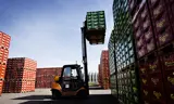 A forklift lifting crates of Carlsberg at a storage depot.